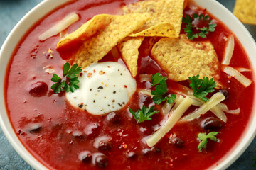 Wall Mural - Mexican Chilli bean soup with yogurt, cheese, lime and tortilla chips in white bowl