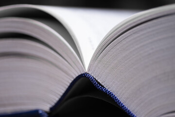 Open book with blue cover with narrow depth of field. Only the right-hand part of the book's pages are sharp