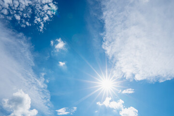 sun on blue sky with sunbeams and clouds in the day