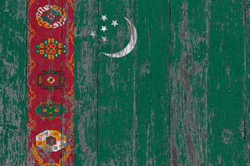 Turkmenistan flag on grunge scratched wooden surface. National vintage background. Old wooden table scratched flag surface.