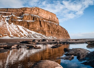 Sticker - Beautiful shot of a lake in front of a snowy mountain with blue sky in the background