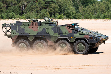 A Boxer military armoured fighting vehicle driving in the sand. 