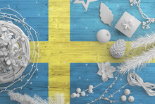 Sweden Flag On Wooden Table With Snow Objects. Christmas And New Year Background, Celebration National Concept With White Decor.