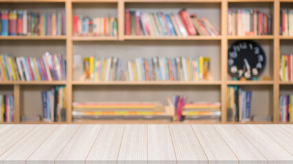 Wooden table in the library with a blurred bookshelf with many book in the background for education concept.