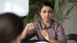 © fizkes - Head shot interested Indian businesswoman intern attentively listening to mentor coach at meeting, business partners negotiation, sitting at table in boardroom, serious hr manager making decision