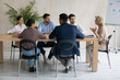 © fizkes - Serious middle aged businesswoman leading corporate meeting with diverse employees team, business people listening to mentor coach at briefing, sitting at conference table in boardroom