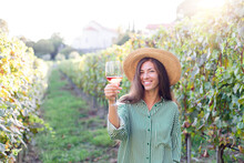 Woman With Wineglass Of Pink Wine In Vineyard At Sunset. Wine Tasting In Winery. Traveler Enjoying Local Tourism And Summer Vacation. Happy Celebration And Social Distance. Authentic Lifestyle.