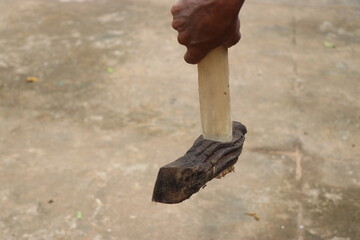 Very old and rusty axe with new wooden handle held in hand