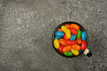 Wall Mural - Multicolor jelly beans in mug on table