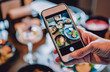 woman hand with smartphone photographing food at restaurant or cafe