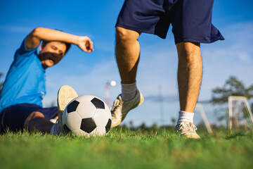 An action sport picture of a man playing soccer football for exercise underblue sky.