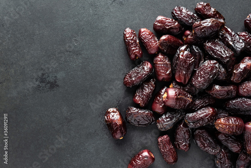 Fotomural Dried red dates on black slate background, top view copy space