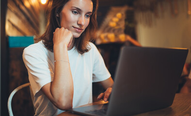 Wall Mural - female manager using laptop in cafe interior, hipster girl freelancer looking on computer monitor, businesswoman working portable computer, woman online learning at home, internet communication