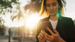 © A_B_C - successful business woman texting on smartphone working in park barcelona sun day, Young professional finance girl using mobile device on background sun flare outdoors