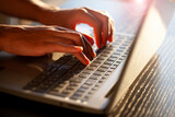 Manos escribiendo en teclado de ordenador portátil