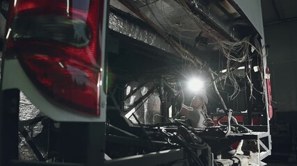 Wall Mural - Auto Mechanic Replacing Faulty Engine In Empty Compartment Located In Back Of Bus.