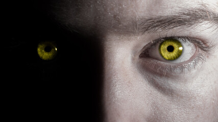 Creepy yellow colorful human eyes glowing in the dark close up macro portrait