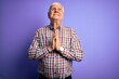 © Krakenimages.com - Senior handsome hoary man wearing casual colorful shirt over isolated purple background begging and praying with hands together with hope expression on face very emotional and worried. Begging.
