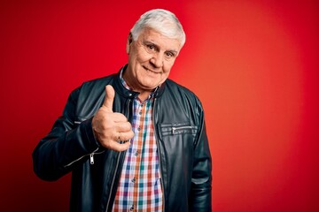 Wall Mural - Senior handsome hoary man wearing casual shirt and jacket over isolated red background doing happy thumbs up gesture with hand. Approving expression looking at the camera showing success.