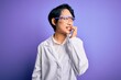 © Krakenimages.com - Young beautiful asian scientist girl wearing coat and glasses over purple background looking stressed and nervous with hands on mouth biting nails. Anxiety problem.