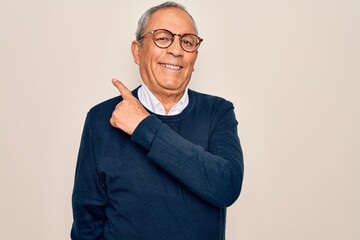 Sticker - Senior handsome grey-haired man wearing sweater and glasses over isolated white background cheerful with a smile of face pointing with hand and finger up to the side with happy and natural expression