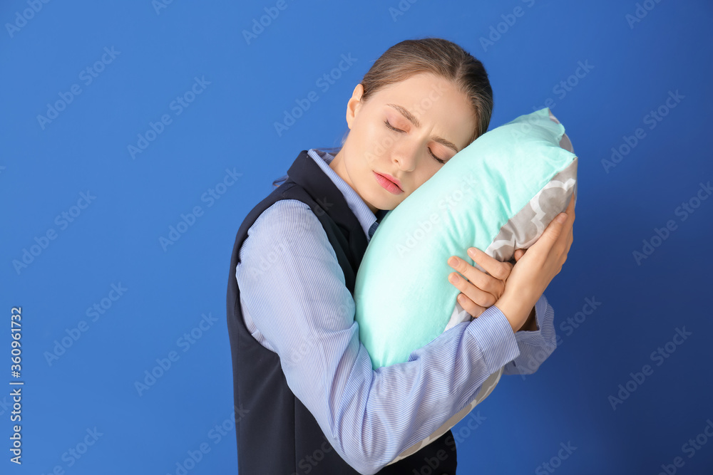 Tired woman with pillow on color background. Concept of sleep deprivation