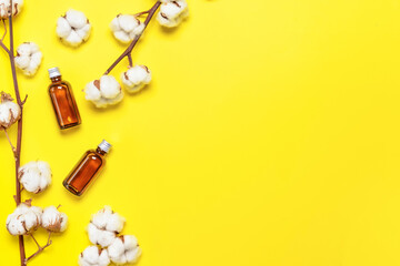 Cotton flowers with cosmetics on color background