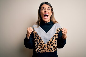 Wall Mural - Young beautiful woman wearing casual sweatshirt standing over isolated white background angry and mad screaming frustrated and furious, shouting with anger. Rage and aggressive concept.