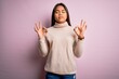 © Krakenimages.com - Young beautiful asian girl wearing casual turtleneck sweater over isolated pink background relax and smiling with eyes closed doing meditation gesture with fingers. Yoga concept.