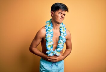 Poster - Young handsome tourist man on vacation wearing swimwear and hawaiian lei flowers with hand on stomach because indigestion, painful illness feeling unwell. Ache concept.