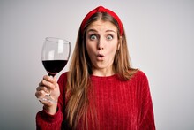 Young Beautiful Redhead Woman Drinking Glass Of Red Wine Over Isolated White Background Scared In Shock With A Surprise Face, Afraid And Excited With Fear Expression
