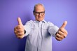 © Krakenimages.com - Middle age handsome hoary man wearing striped shirt and glasses over purple background approving doing positive gesture with hand, thumbs up smiling and happy for success. Winner gesture.