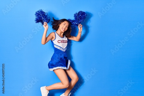 Fotografía Young beautiful chinese girl smiling happy wearing cheerleader uniform