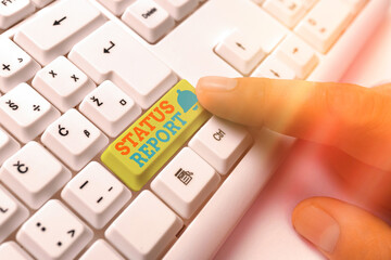 Poster - Handwriting text Status Report. Conceptual photo summarizes the particular situation as of a stated period White pc keyboard with empty note paper above white key copy space