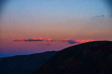 Wall Mural - atmospheric minimal dawn landscape with dark silhouette of mountains under vivid lilac blue gradient