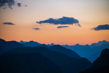 Wall Mural - colorful dawn landscape with beautiful mountains silhouettes and golden gradient sky with blue cloud