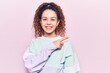 © Krakenimages.com - Beautiful kid girl with curly hair wearing casual sporty clothes smiling cheerful pointing with hand and finger up to the side