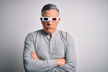 Canvas Print - Middle age handsome grey-haired man using 3d glasses over isolated white background skeptic and nervous, disapproving expression on face with crossed arms. Negative person.