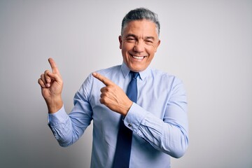 Poster - Middle age handsome grey-haired business man wearing elegant shirt and tie smiling and looking at the camera pointing with two hands and fingers to the side.