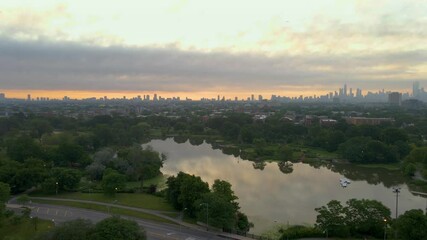 Wall Mural - 4k aerial drone view of Chicago park Humboldt Park neighborhood.  the sunrise creates a beautiful atmosphere of  vibrant green trees and lush pond for a healthy environment