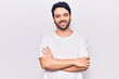 © Krakenimages.com - Young hispanic man wearing casual clothes happy face smiling with crossed arms looking at the camera. positive person.