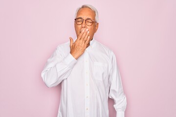 Wall Mural - Middle age senior grey-haired man wearing glasses and business shirt over pink background bored yawning tired covering mouth with hand. Restless and sleepiness.