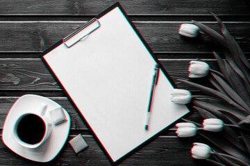 Wall Mural - White tulips on a wooden table with a Cup of coffee and an empty paper tablet