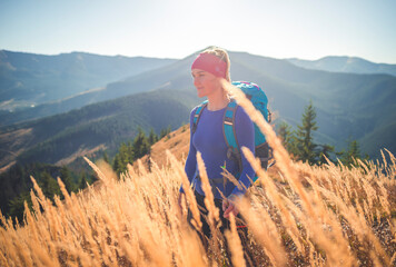 Hiking in summer sunny day in mountains. Hikers walking in nature on top of cliff and enjoying view. Tourist mountain outdoors concept.