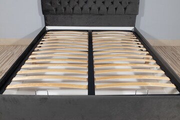 Sticker - Bed with gray fabric upholstery and a wooden frame without mattress