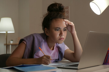 Canvas Print - Young woman using laptop for online learning at home