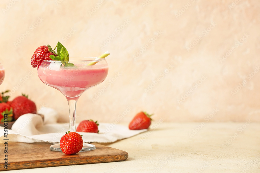 Glass of tasty strawberry smoothie on table