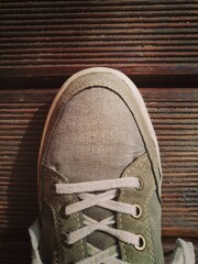 Canvas Print - Close up shot of a beige sneaker on plywood