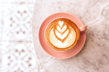 Wall Mural - Pink cup of cappuccino on marble table background. Love latte art on the top of it.