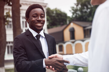 Wall Mural - Selective focus of handsome businessman hand shaking. Cropped view of young adult african american recruiter have a business meeting with european male. Multiracial relationship concept.
